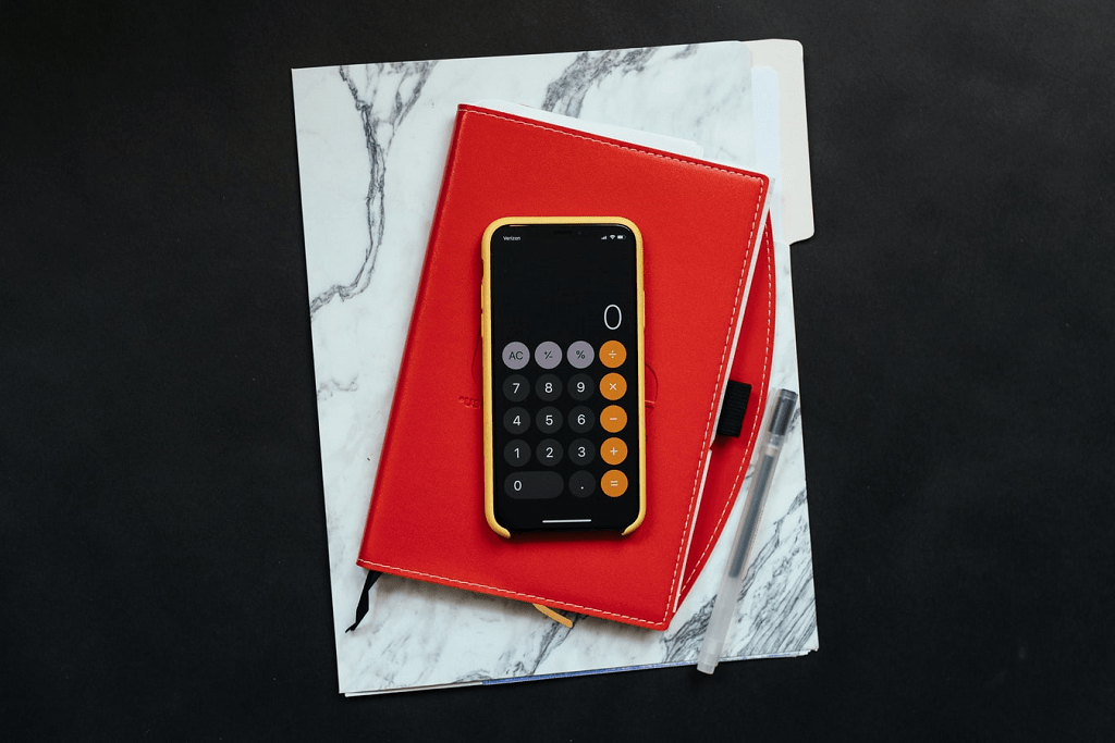 Um caderno e a calculadora do celular para controlar os gastos