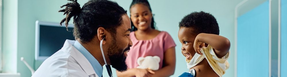 Médico sorridente examinando uma criança em um consultório
