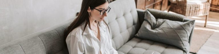 mulher sentada no sofá usando o notebook