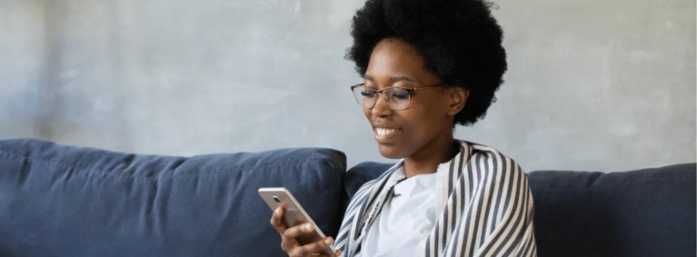 mulher sentada no sofá usando um celular