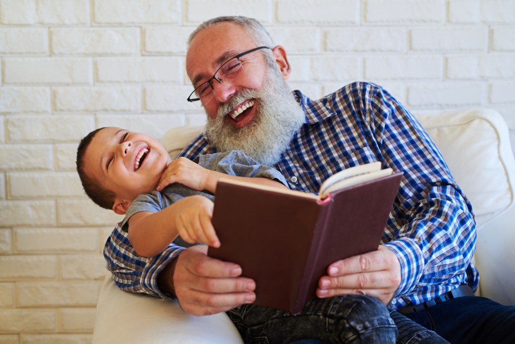 Avô e neto lendo livros e se divertindo. 