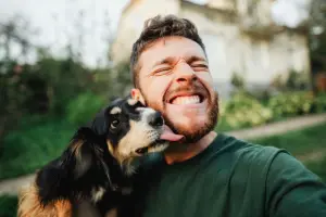 Selfie de homem sorrindo com um cachorro