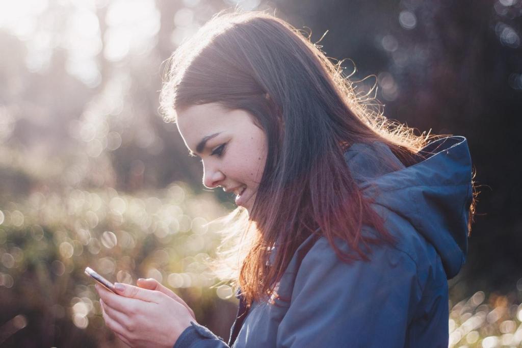 Garota em uma floresta, sorrindo enquanto mexe no celular