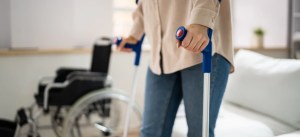 Pessoa usando muletas em ambiente interno, possivelmente em reabilitação ou recuperação de uma lesão