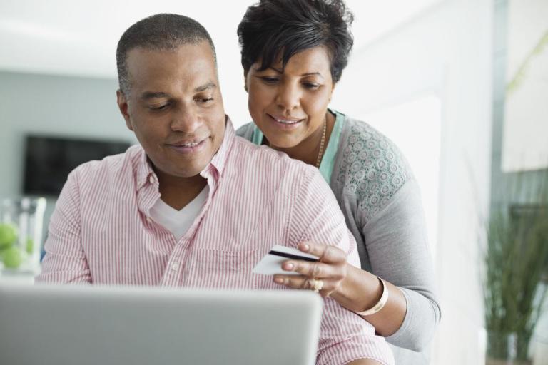 Casal sentados, usando um noteboolk, para entender como funciona a inflação.