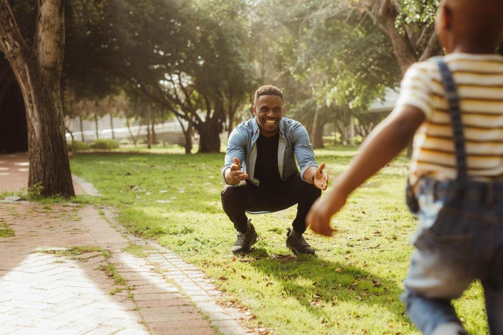 Homem brincando com seu filho no parque. 