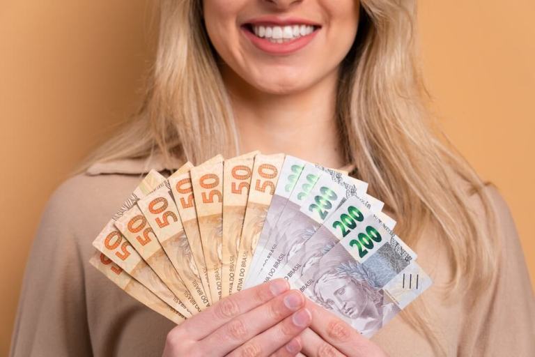 mulher loira sorridente com dinheiro na mãos