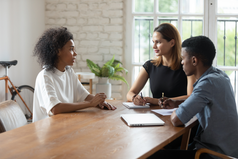 Três pessoas conversando sobre uma mesa