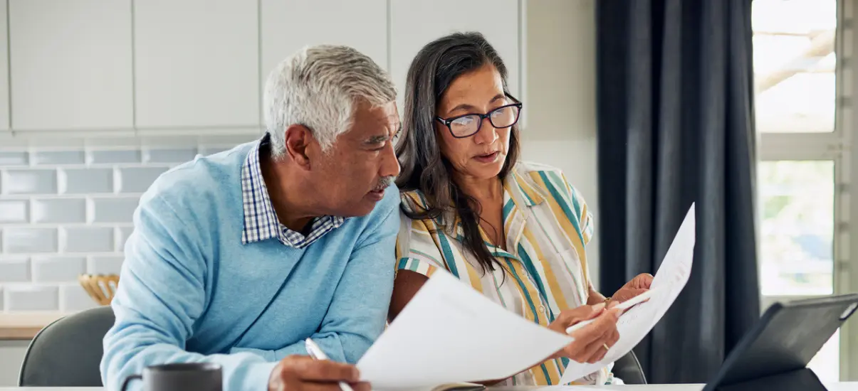 imagem de um casal de idosos lendo na cozinha