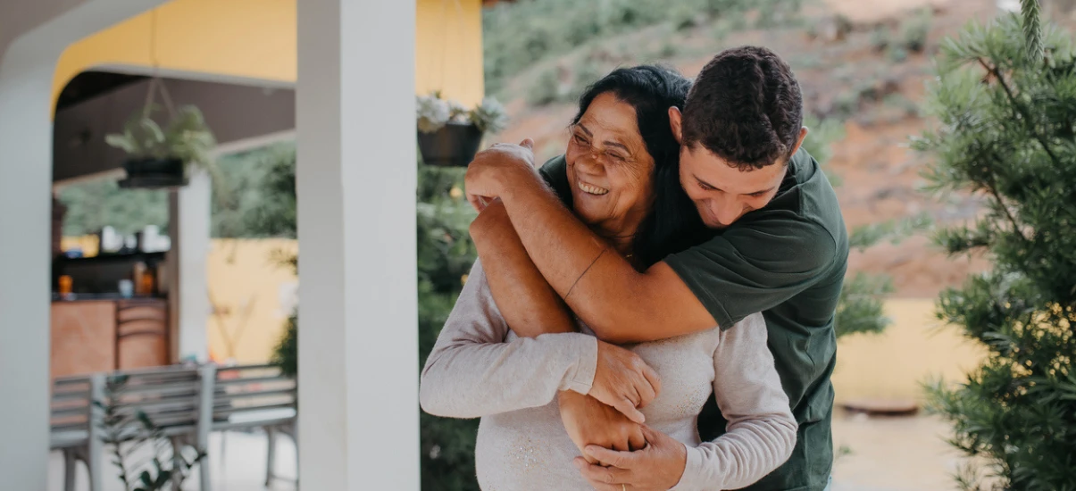 Momente emocionantes de afeto entre uma mãe e seu filho ao ar livre, demonstrando amor, carinho e conexão familiar, em um ambiente natural e acolhedor.