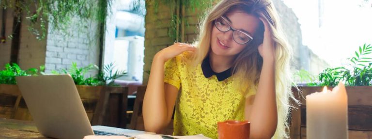 Moça feliz usando o notebook sobre a mesa