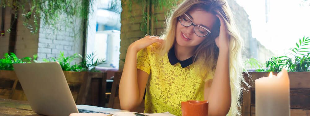 Moça feliz usando o notebook sobre a mesa