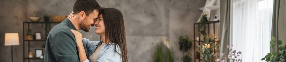 Casal apaixonado se abraçando em ambiente moderno e acolhedor, simbolizando amor e união em um lar contemporâneo.