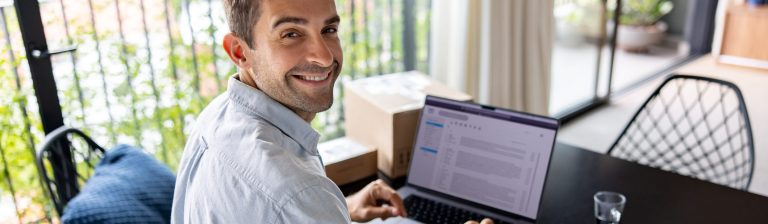 Homem sorrindo usando o notebook
