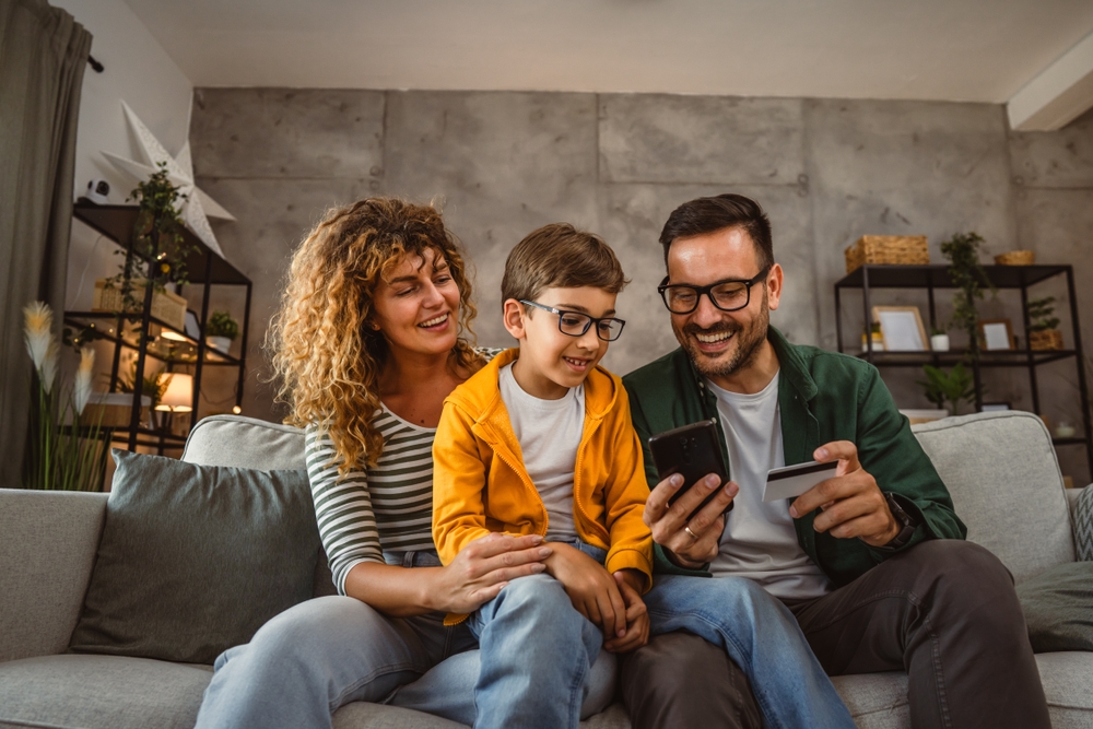 família feliz no sofá da sala de estar com o filho no colo