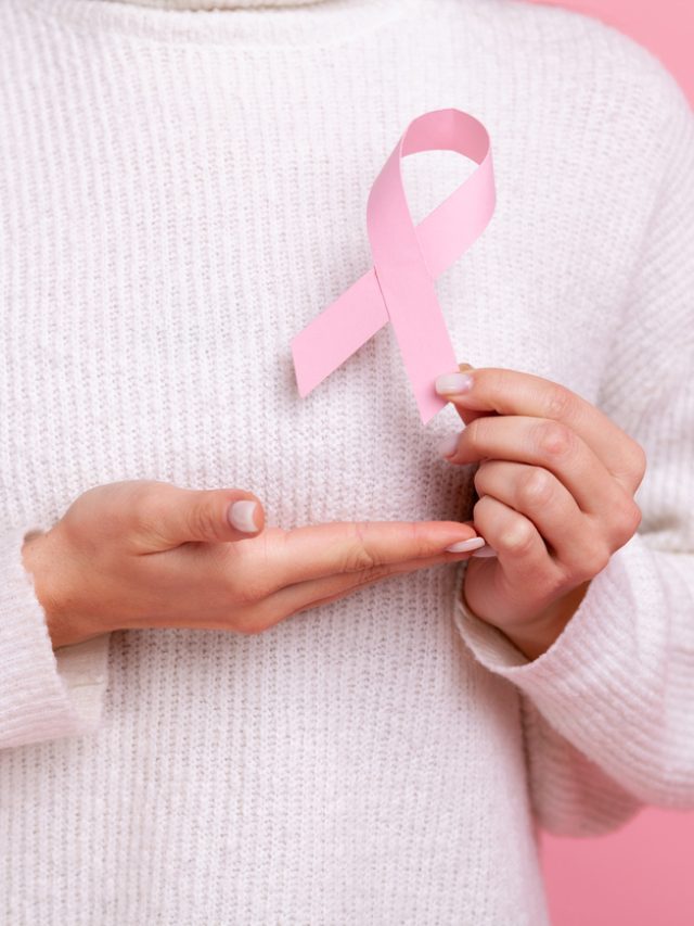 imagem de uma mulher segurando a fita do outubro rosa