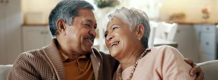 casal de idosos sorrindo se olhando