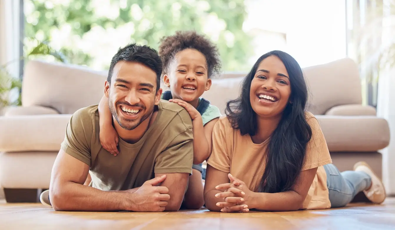 família feliz deitada no chão, com pai mãe e filha