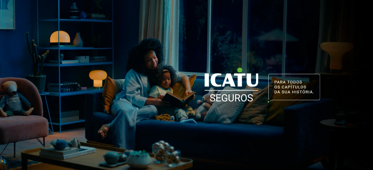 Imagem retratando mãe e filha sentadas confortavelmente no sofá, lendo juntas. A cena transmite uma sensação de acolhimento e segurança, destacando a mensagem da ICATU Seguros.