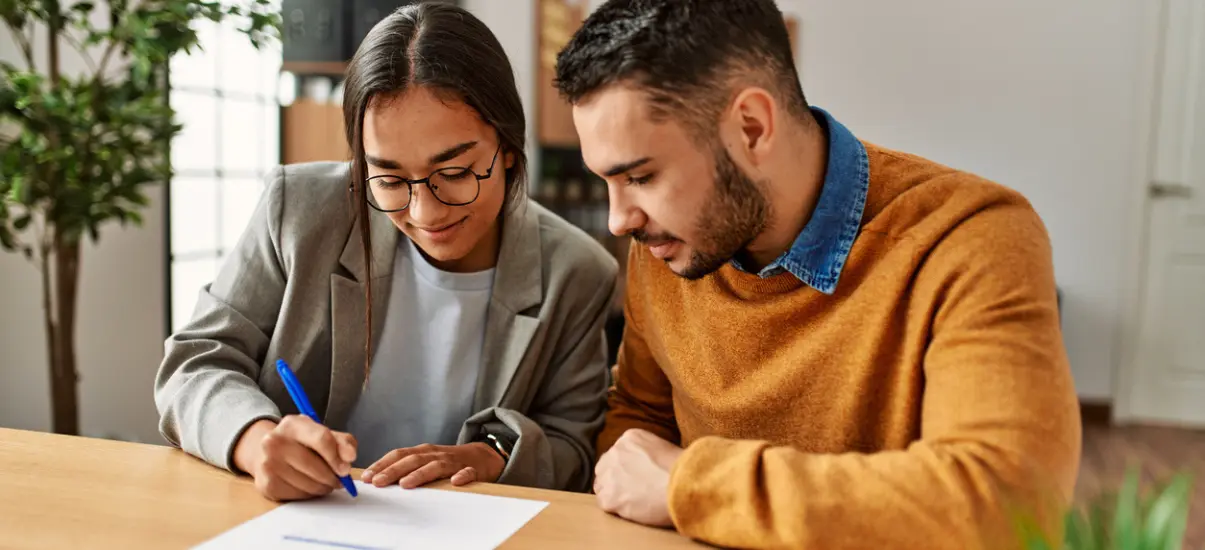 imagem de um casal assinando documentos