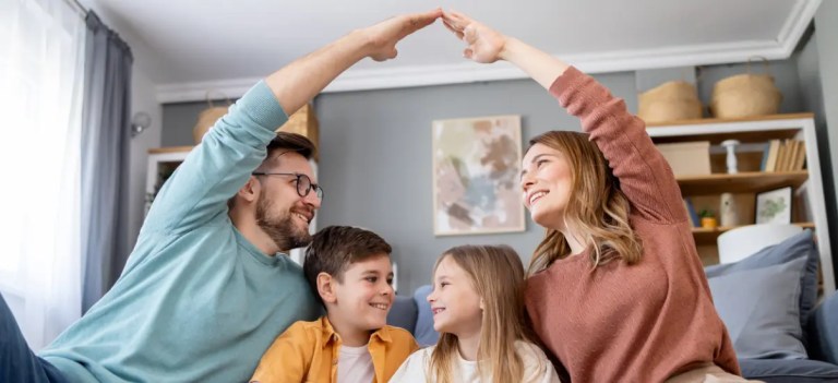 casal feliz sentado na sala com os seus filhos