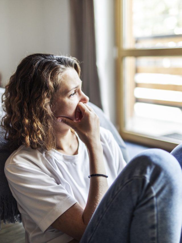 mulher triste olhando para a janela