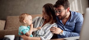 Família feliz com uma criança pequena em um ambiente de sala de estar, comemorando momentos juntos, capturado em uma foto com foco na alegria familiar.
