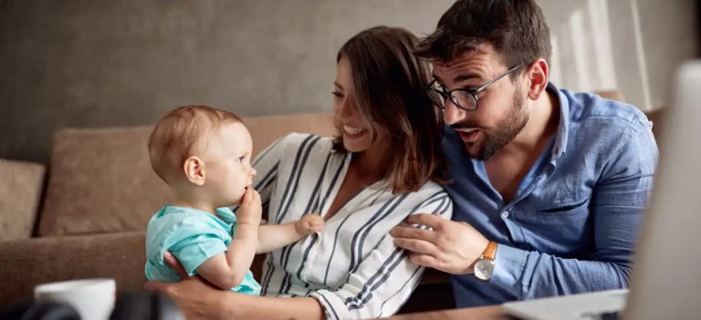 Família feliz com uma criança pequena em um ambiente de sala de estar, comemorando momentos juntos, capturado em uma foto com foco na alegria familiar.