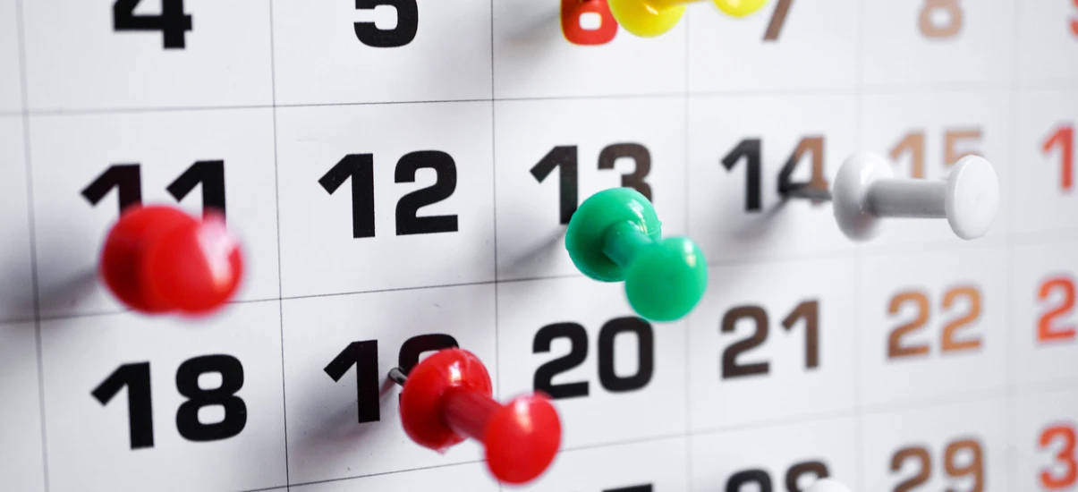 Planejamento e controle de atividades no calendário, com bolinhas coloridas marcando datas importantes na organização.