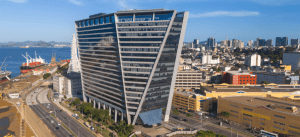 Imagem do edifício Le Monde Tower em Valparaíso, Chile, destaque na paisagem urbana com sua arquitetura moderna e estrutura inovadora, próximo ao mar.